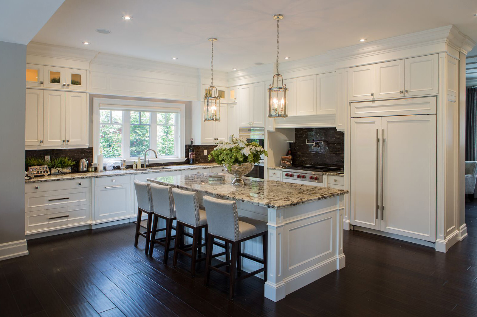 Custom white kitchen with a granite island and pendant lighting